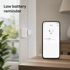 Low battery reminder screen beside white Zigbee door sensor