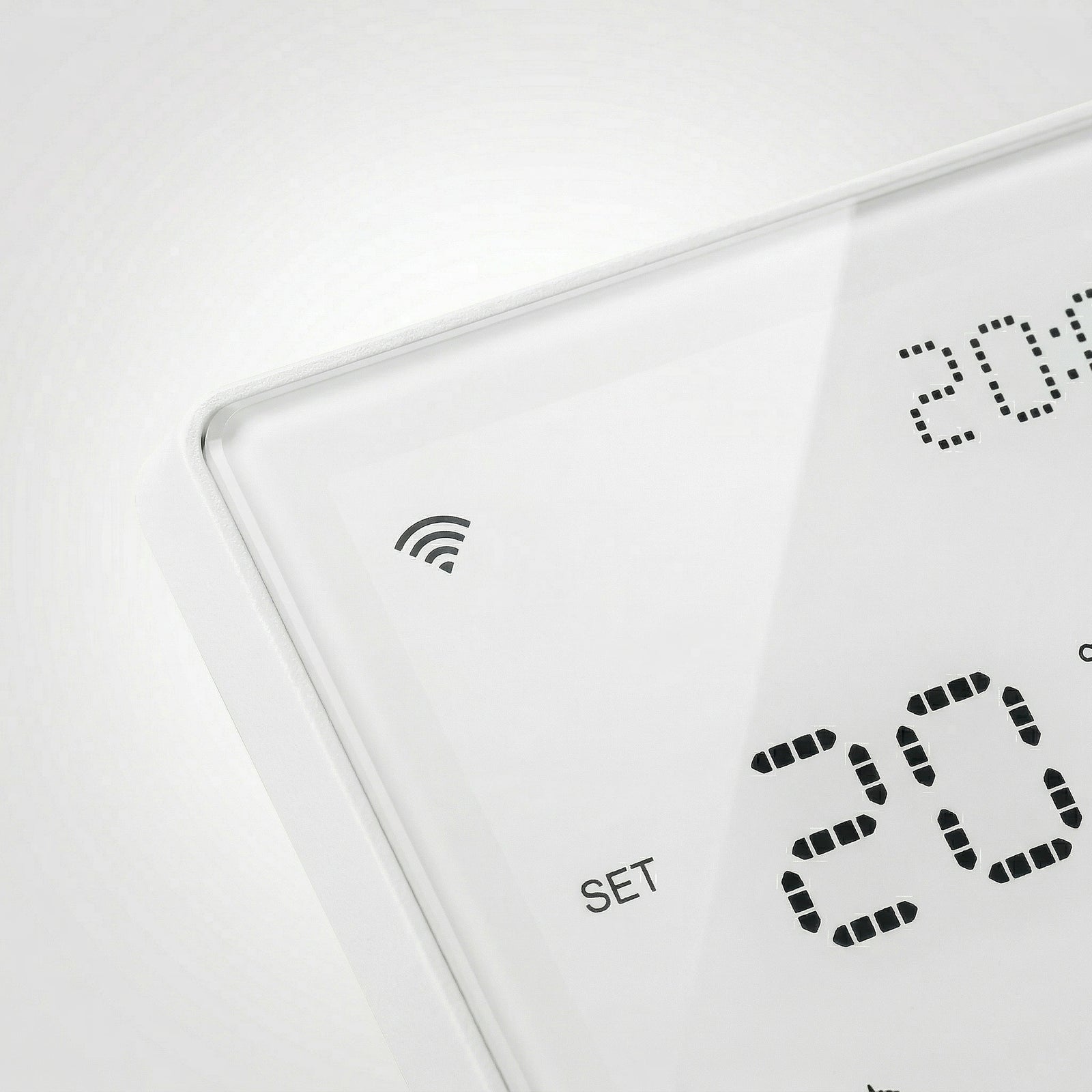 Gros plan sur le thermostat mural NéoPure Comfort blanc pur avec symbole Wi‑Fi et affichage LED.
