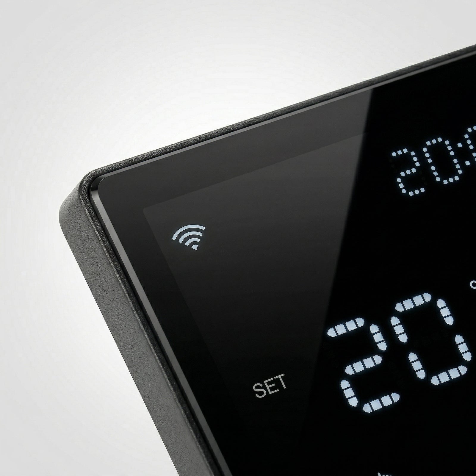 Gros plan sur le thermostat mural NéoPure Comfort noir absolu avec symbole Wi‑Fi et affichage LED.