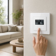 White Wi-Fi wall thermostat adjusted by hand in a modern living room