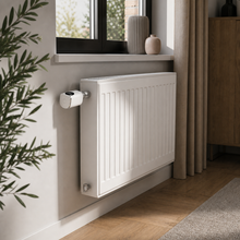 Smart thermostatic radiator valve installed on a white radiator in a modern home interior