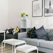 NéoStation Comfort blanc installé au mur dans un salon lumineux avec canapé gris.