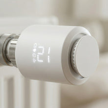 Détail d’une vanne thermostatique blanche installée sur radiateur.